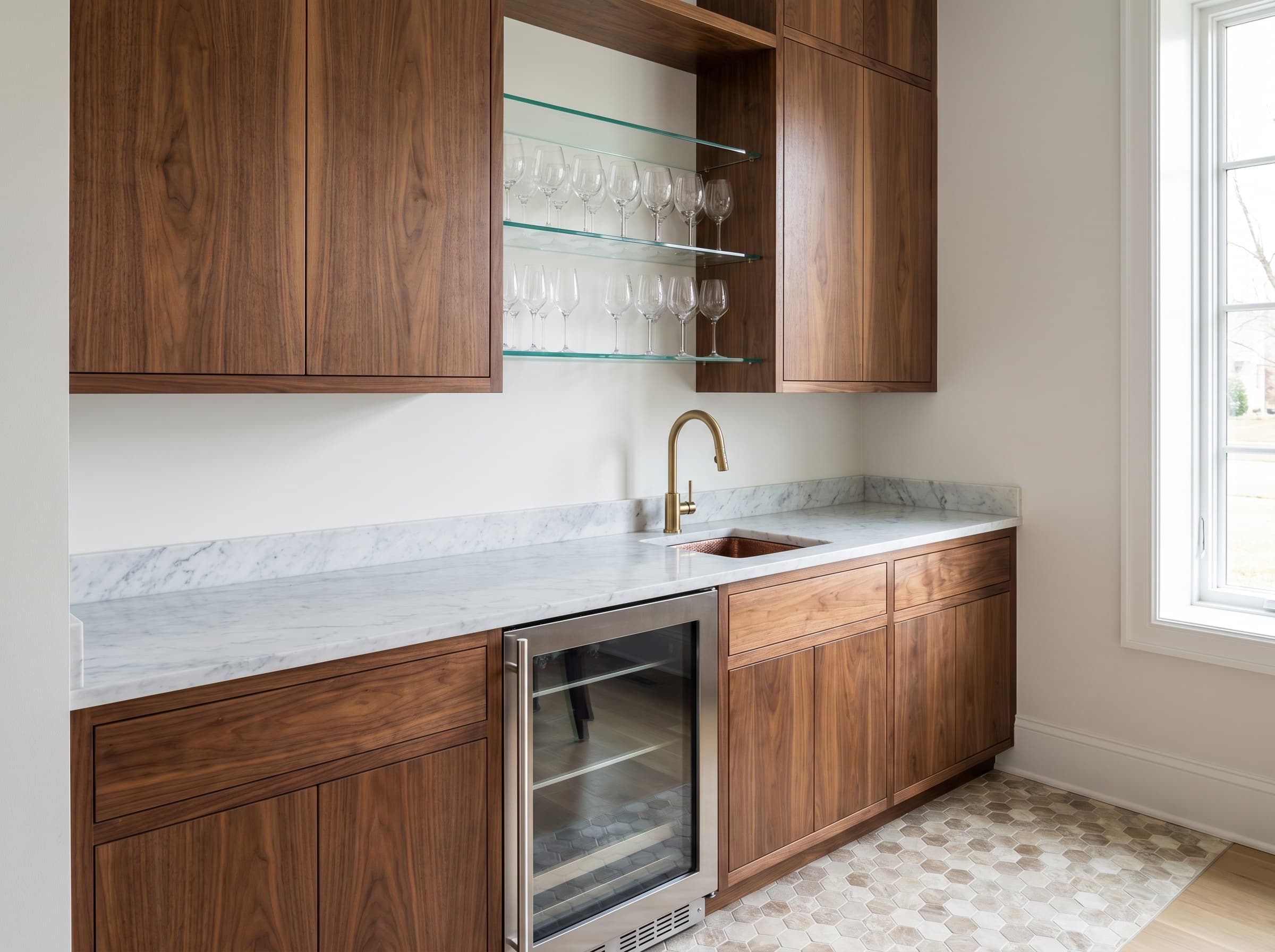 Brookhaven, GA · Walnut slab wet bar with glass stemware shelves and beverage fridge.