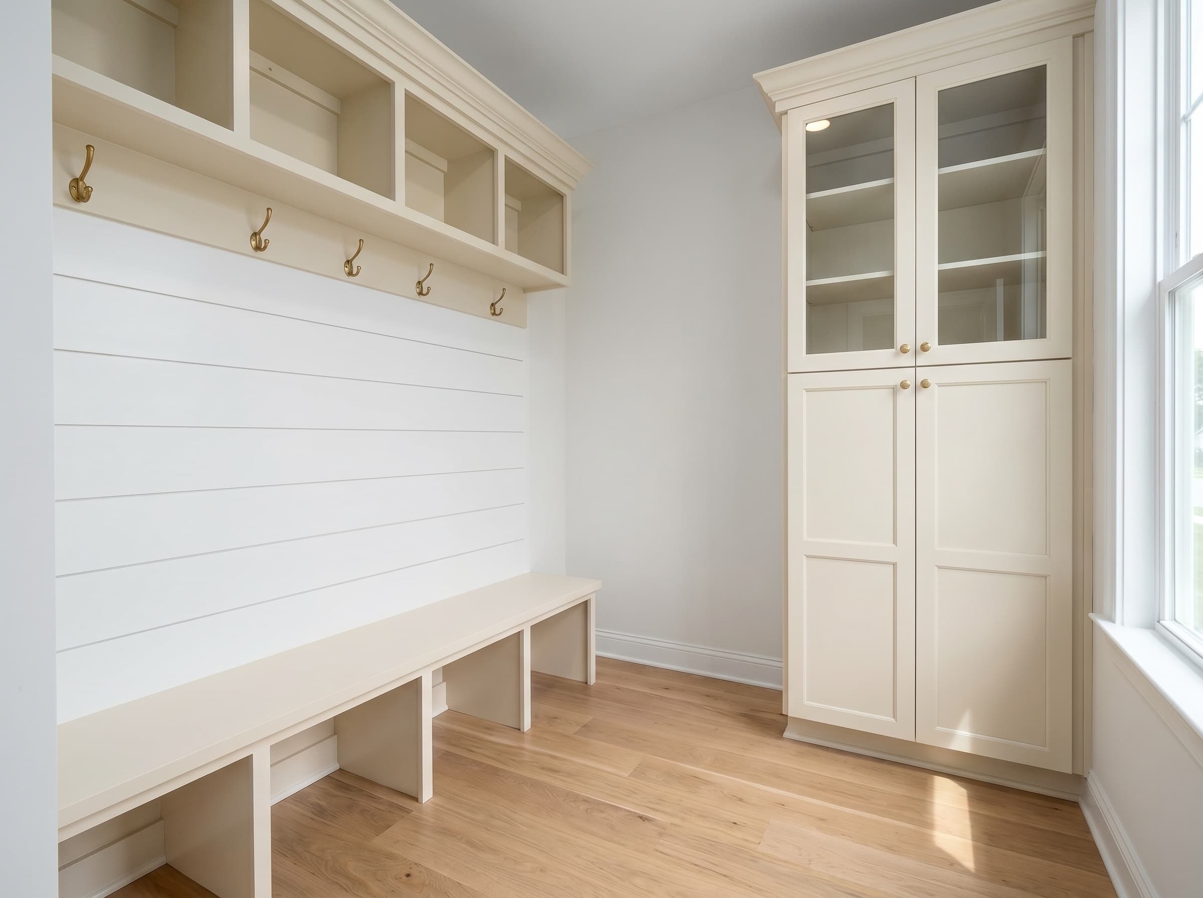 Buford, GA · Cream shaker mudroom-built-in with bench and tall glass-front storage.