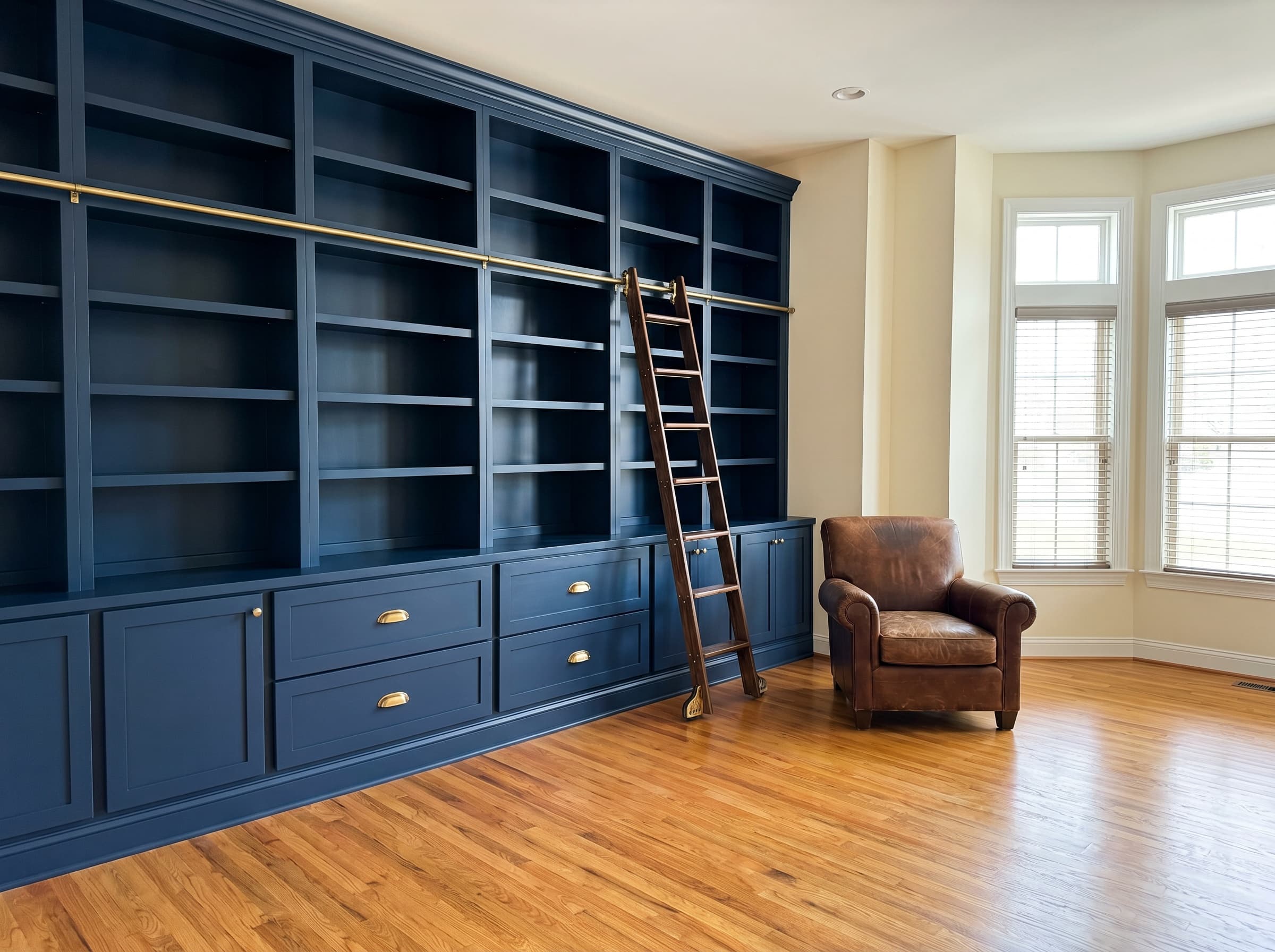 Lawrenceville, GA · Deep navy library wall with sliding brass-rail ladder.