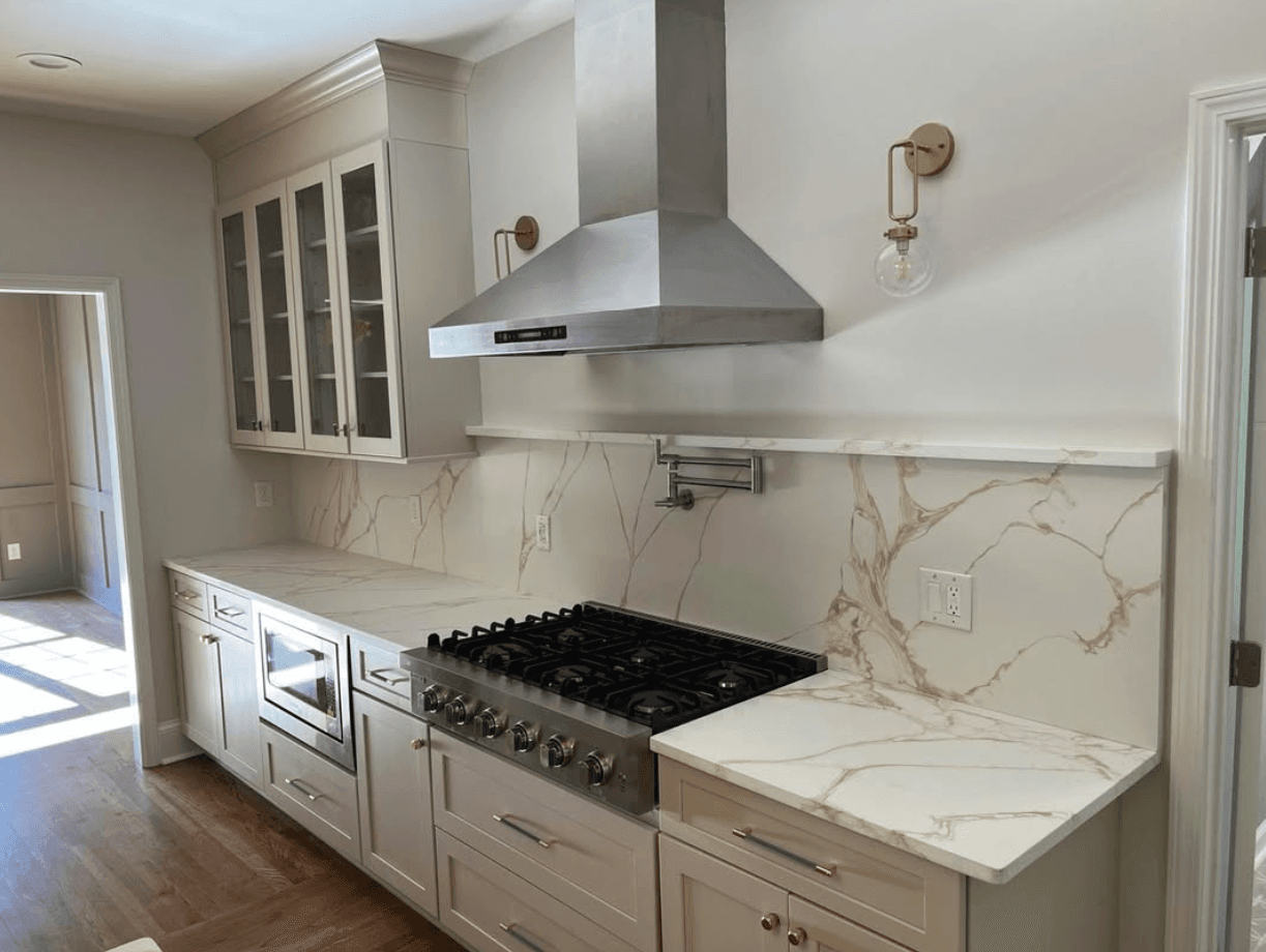 Johns Creek, GA · Open-concept white kitchen with center island and pendant lights.