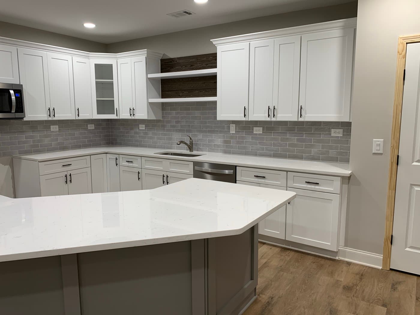 Decatur, GA · Custom kitchen cabinets with quartz tops and pendant lighting.