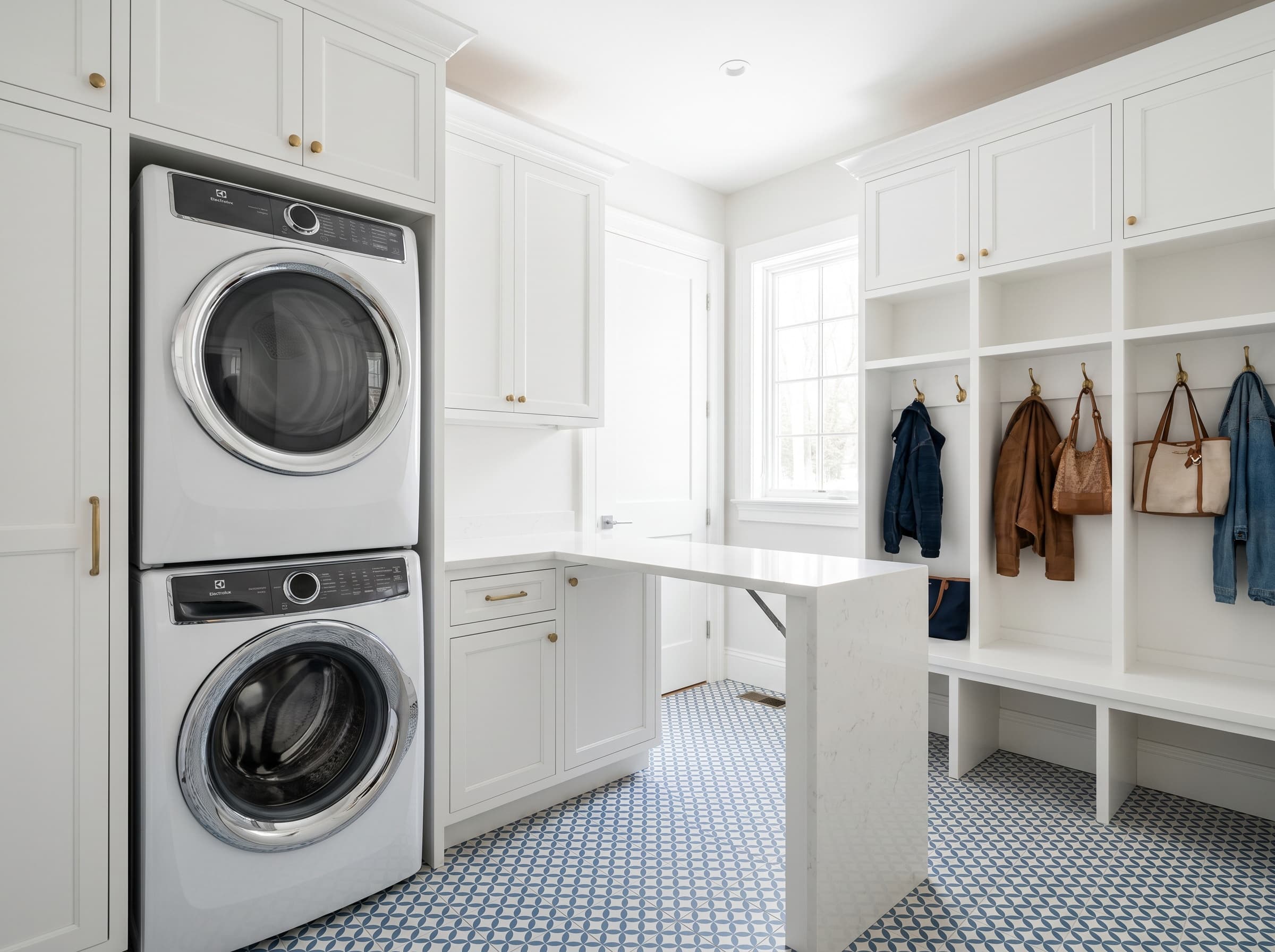 Woodstock, GA · Laundry-mudroom combo with bench, cubbies, and brass hooks.