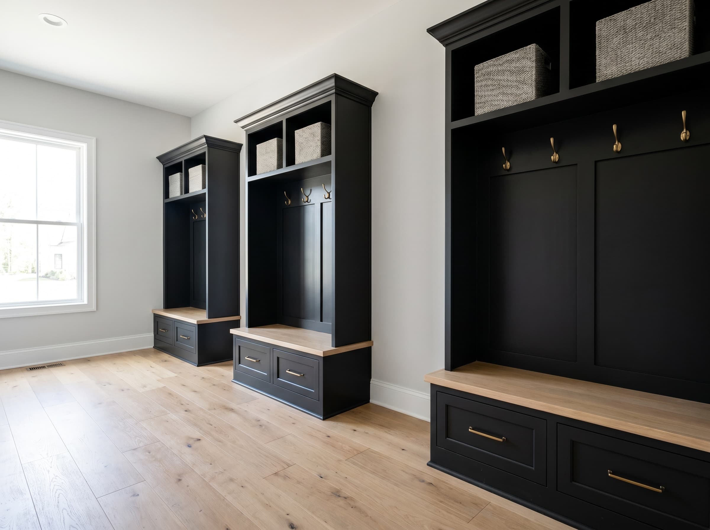 Brookhaven, GA · Three tall matte black shaker open lockers with brass hooks.
